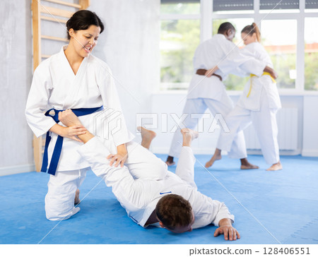 Cosmopolite sportsmen train of performing protection with wring hands during training in aikido 128406551