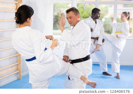 Multinational pupils train to perform defensive karate installations and attacking combat techniques 128406576