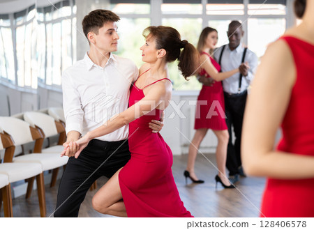 Young guy and adult woman dance tango 128406578