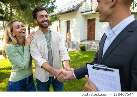 Happy couple greeting agent at new house in suburban setting Happy couple greeting agent at new house in suburban setting 128407544