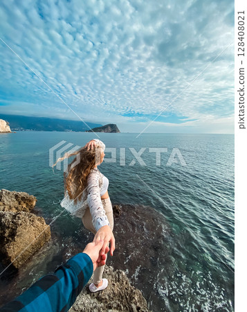 A Romantic Beach Adventure Holding Hands While Strolling Along the Beautiful Sea 128408021