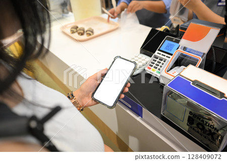 Female customer preparing to pay with a smartphone at a register 128409072