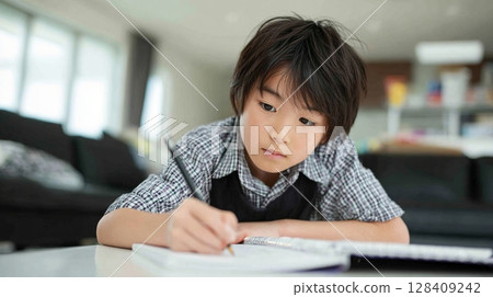 Elementary school boy concentrating on studying at his desk | Learning, effort, future, growth, home learning 128409242