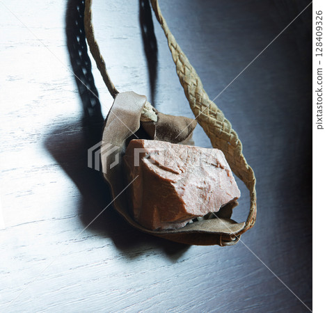 Sling with stone on wooden background Sling with stone on wooden background 128409326