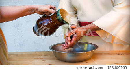 The servant pours water, and the master washes his hands 128409363