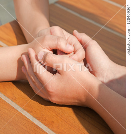 Close-up view of comforting hands 128409364