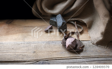 An antique leather sling lies on wooden desk An antique leather sling lies on wooden desk 128409370