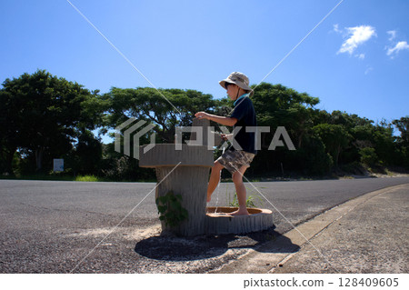 ※<Material>A boy washing his feet at the beach in summer ※<Material>A boy washing his feet at the beach in summer 128409605