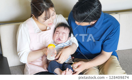 一名男子和一名婦女用奶瓶餵食嬰兒 128409874