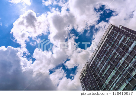 Yokohama cityscape in Japan. Apartment building repairs and inspections, scaffolding and protective nets. Satellite antennas outside the nets. 128410057