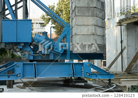 Blue Crane Base and Concrete Counterweights on Construction Site 128410123