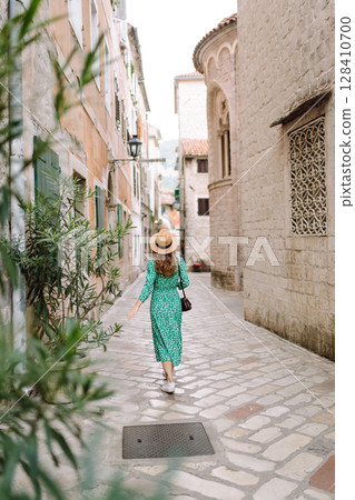 Young woman in beautiful dress walking in the street of the city. Eurotrip. Travel, tourism. Fashion Young woman in beautiful dress walking in the street of the city. Eurotrip. Travel, tourism. Fashion 128410700