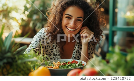 Young Woman Enjoying a Colorful Salad in a Vibrant Indoor Garden Setting During Daylight Hours 128410732
