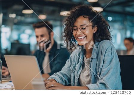 Creative Team Collaboration Takes Place in a Modern Workspace With Two Professionals Engaged and Smiling While Using Laptops Creative Team Collaboration Takes Place in a Modern Workspace With Two Professionals Engaged and Smiling While Using Laptops 128410760