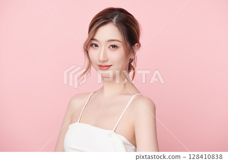 A beautiful young Asian woman with clean, fresh skin against a pink background. Skincare, facial treatment, cosmetology, beauty, and spa. An elegant portrait of an Asian woman. A beautiful young Asian woman with clean, fresh skin against a pink background. Skincare, facial treatment, cosmetology, beauty, and spa. An elegant portrait of an Asian woman. 128410838