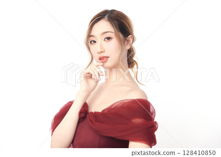 A beautiful young Asian woman with clean, fresh skin against a white background. Skincare, facial treatment, cosmetology, beauty, and spa. An elegant portrait of an Asian woman. 128410850