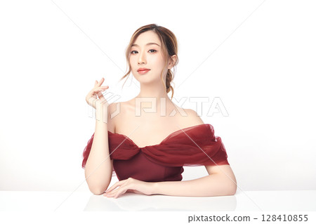 A beautiful young Asian woman with clean, fresh skin against a white background. Skincare, facial treatment, cosmetology, beauty, and spa. An elegant portrait of an Asian woman. 128410855