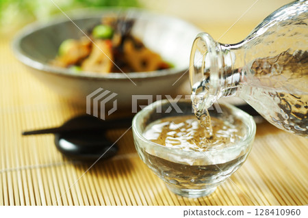 Pouring sake and stewed hijiki and edamame 128410960