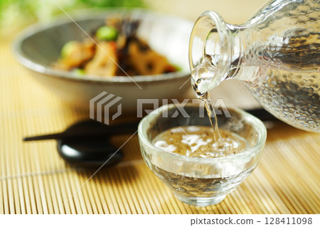 Pouring sake and stewed hijiki and edamame 128411098