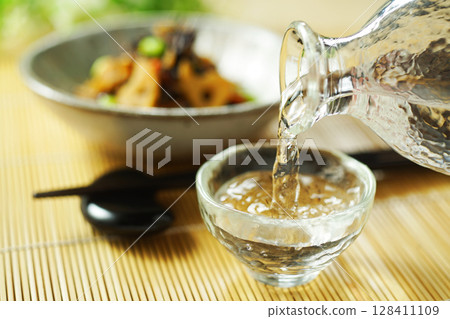 Pouring sake and stewed hijiki and edamame 128411109