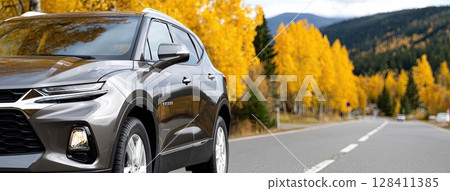 Black SUV navigates a scenic road surrounded by bright yellow trees during autumn, showcasing the beauty of fall foliage Black SUV navigates a scenic road surrounded by bright yellow trees during autumn, showcasing the beauty of fall foliage 128411385