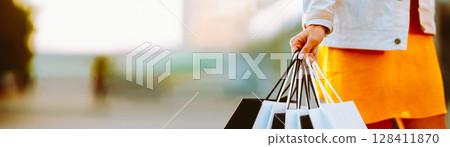Young woman with shopping bags walking on street. Female coming from a sale downtown Young woman with shopping bags walking on street. Female coming from a sale downtown 128411870