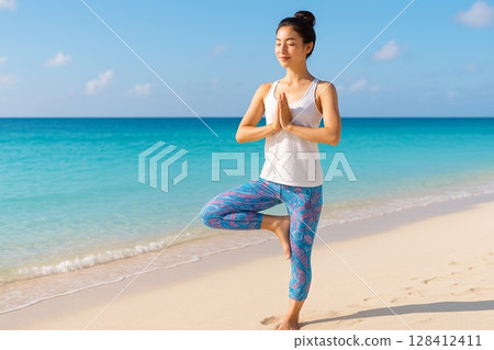 Young woman doing yoga poses on the beach in Okinawa 128412411