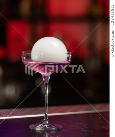 This visually striking pink alcoholic cocktail in a coupe glass features a large, dome-shaped smoke bubble on top, with more smoke billowing around it This visually striking pink alcoholic cocktail in a coupe glass features a large, dome-shaped smoke bubble on top, with more smoke billowing around it 128412615