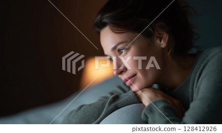 Thoughtful woman gazing, lost in contemplation. Reflective mood in soft light, conveying peace and introspection. Great for mental health or lifestyle themes. Thoughtful woman gazing, lost in contemplation. Reflective mood in soft light, conveying peace and introspection. Great for mental health or lifestyle themes. 128412926