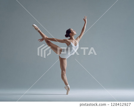 Elegant ballet dancer in a graceful pose. Strength, poise, and artistry captured in a modern, clean aesthetic. Ideal for dance, fitness, and wellness themes. 128412927