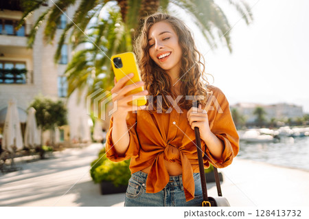 Young woman walking down street and using mobile phone. Business, technology, blogging concept. 128413732