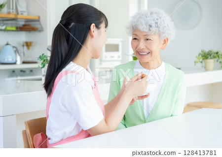 一位女護理員在客廳照顧一位老年婦女 128413781