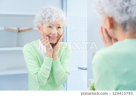 Senior woman doing skin care in the bathroom 128413793