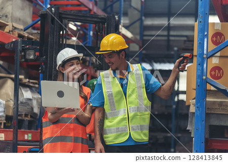 Warehouse management team using computer laptop check stock inventory. Asian men women worker use software computer type keyboard goods shelf. Teamwork logistics staff counting stock store inventory 128413845