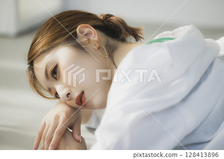 A woman lying on the floor 128413896