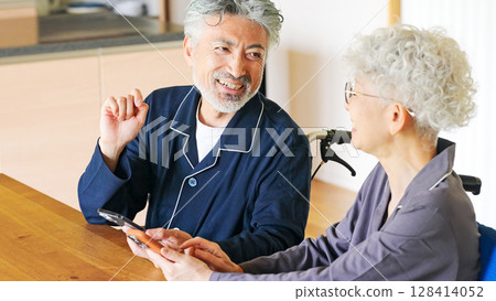 Smiling senior couple using a smartphone Smiling senior couple using a smartphone 128414052