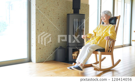 Senior woman relaxing in a rocking chair Senior woman relaxing in a rocking chair 128414056