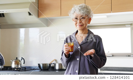 Senior woman taking pills Senior woman taking pills 128414101