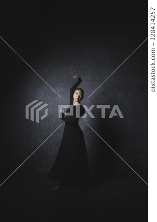 Woman posing against black background Woman posing against black background 128414257