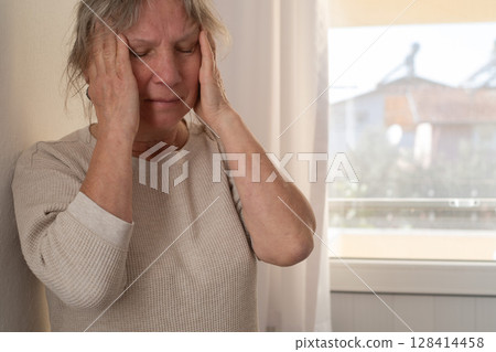 Elderly Woman Suffering from a Migraine 128414458