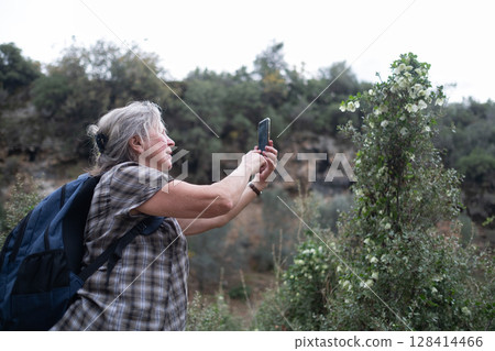 Elderly Woman Taking Photos During a Hike Elderly Woman Taking Photos During a Hike 128414466