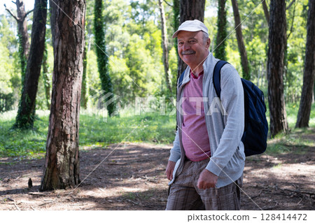 Elderly Man Walking Through the Forest During Vacation 128414472