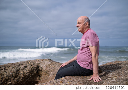 Elderly Man Sitting on the Beach and Looking at the Ocean, Remembering His Youth in Portugal Elderly Man Sitting on the Beach and Looking at the Ocean, Remembering His Youth in Portugal 128414501