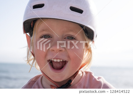 Girl in a Bike Helmet Happily Looking at the Camera 128414522