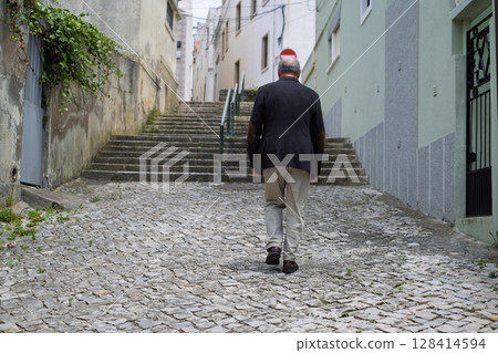 Elderly Man Walking up Narrow Portuguese Streets  128414594