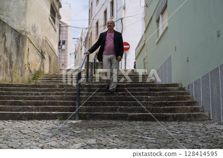 Elderly Man Walking up Narrow Portuguese Streets Elderly Man Walking up Narrow Portuguese Streets 128414595