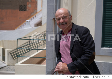 Elderly Spanish Man Walking in a Portuguese City and Looking at the Ocean. He Wears a Jacket and Has a Mustache Elderly Spanish Man Walking in a Portuguese City and Looking at the Ocean. He Wears a Jacket and Has a Mustache 128414596