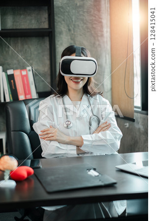 Female doctor in white coat using VR headset in office, exploring virtual medical training and simulation. 128415041