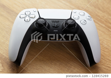 Sony PS5 Wireless Controller, on an oak wooden table, PlayStation is a video gaming brand that consists of five home video game consoles. Istanbul Turkey May 01 2025 Sony PS5 Wireless Controller, on an oak wooden table, PlayStation is a video gaming brand that consists of five home video game consoles. Istanbul Turkey May 01 2025 128415269