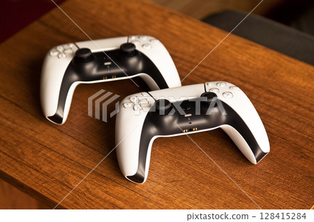 Sony PS5 Wireless Controller, on an oak wooden table, PlayStation is a video gaming brand that consists of five home video game consoles. Istanbul Turkey May 01 2025 128415284